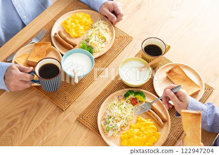 A middle-aged couple eating a Western-style breakfast 122947204