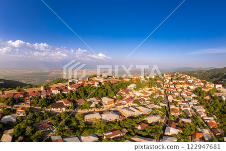 Aerial view on St. George's Church and Alazani valley, Georgia, Kakheti region, Signagi village. Sighnaghi city of love on hill near Gombori Range. Drone Photography in sunny summer day. Aerial view on St. George's Church and Alazani valley, Georgia, Kakheti region, Signagi village. Sighnaghi city of love on hill near Gombori Range. Drone Photography in sunny summer day. 122947681