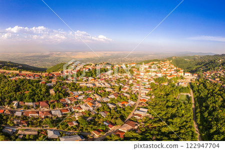 Aerial view on St. George's Church and Alazani valley, Georgia, Kakheti region, Signagi village. Sighnaghi city of love on hill near Gombori Range. Drone Photography in sunny summer day. Aerial view on St. George's Church and Alazani valley, Georgia, Kakheti region, Signagi village. Sighnaghi city of love on hill near Gombori Range. Drone Photography in sunny summer day. 122947704