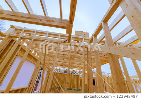 Constructing wooden beams framework for building as they prepare for further development Constructing wooden beams framework for building as they prepare for further development 122948487