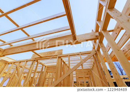 Constructing wooden frame structure with beams trusses in residential area Constructing wooden frame structure with beams trusses in residential area 122948489