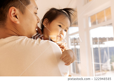 A young Korean father is holding his cute daughter in his arms A young Korean father is holding his cute daughter in his arms 122948585