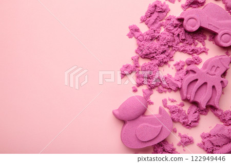 Pink kinetic sand for children, development and play at home with multi-colored sandbox molds on pink background. Pink kinetic sand for children, development and play at home with multi-colored sandbox molds on pink background. 122949446