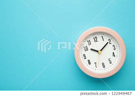 Pink clock on blue background. Top view. Space for text 122949467