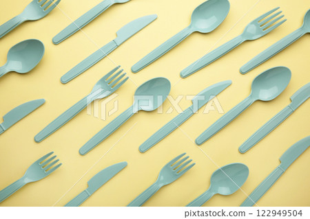 Flay lay photo of blue plastic disposable forks, spoons and knives. Creative top view pattern. 122949504