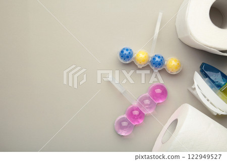 Toilet balls and toilet paper on grey background. Clean the toilet bowl with cleaning and refreshing balls. Toilet balls and toilet paper on grey background. Clean the toilet bowl with cleaning and refreshing balls. 122949527