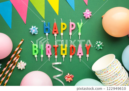 Text Happy Birthday with birthday asseccories, candles and confetti on green background. Text Happy Birthday with birthday asseccories, candles and confetti on green background. 122949610