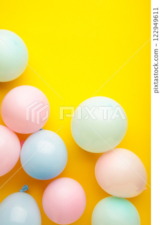 Birthday background with colorful balloons on yellow background, top view Birthday background with colorful balloons on yellow background, top view 122949611