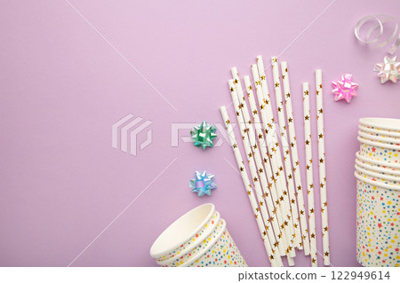 Overhead photo of cups drink cocktail party tubules and multicolored confetti isolated on the yellow wooden background with blank space Overhead photo of cups drink cocktail party tubules and multicolored confetti isolated on the yellow wooden background with blank space 122949614