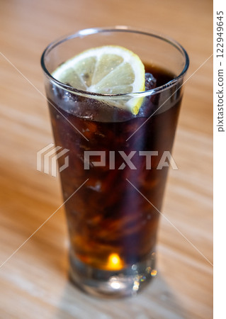 A glass of Cola with a slice of lemon on the table A glass of Cola with a slice of lemon on the table 122949645