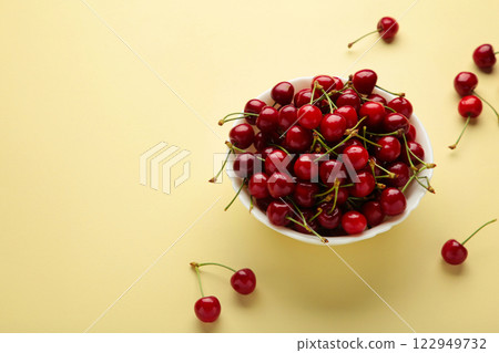 Fresh sweet cherries bowl on beige background, top view Fresh sweet cherries bowl on beige background, top view 122949732