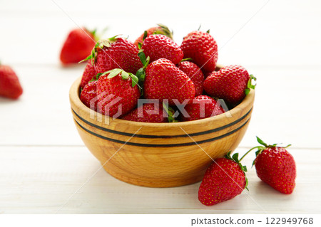 Ripe strawberries in wooden bowl on white background. Space for text 122949768
