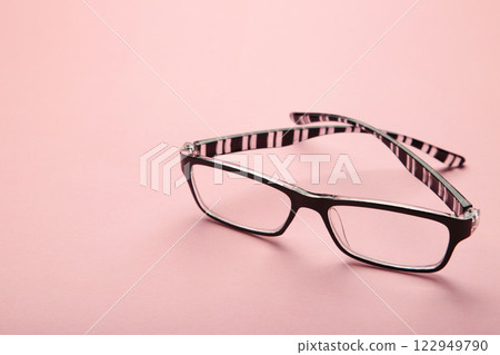 Black eye glasses spectacles with black frame for reading daily life to a person with visual impairment on pink background. 122949790