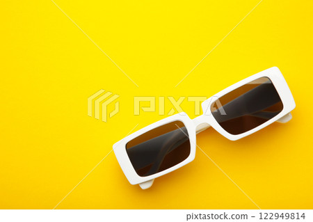 White sunglasses on yellow background, top view, flat lay, minimalistic concept of summer, vacation. White sunglasses on yellow background, top view, flat lay, minimalistic concept of summer, vacation. 122949814