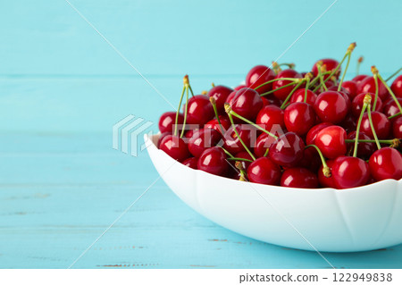 Fresh sweet cherries bowl on blue wooden background, top view Fresh sweet cherries bowl on blue wooden background, top view 122949838