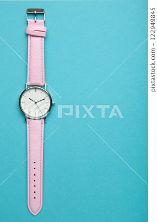 Pink wrist watches on blue background with copy space. Vertical photo 122949845