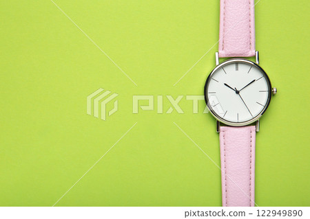 Pink wrist watches on green background with copy space 122949890