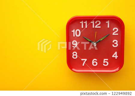 Red wall clock on yellow background. Space for text Red wall clock on yellow background. Space for text 122949892