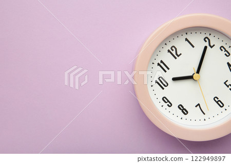 Pink clock on purple background. Top view. Pink clock on purple background. Top view. 122949897