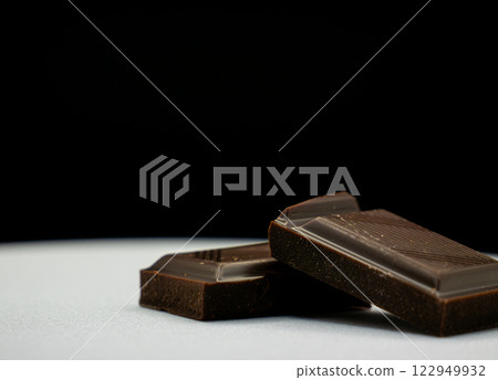Stack of Dark Chocolate Squares on a Dark Background Close-Up Stack of Dark Chocolate Squares on a Dark Background Close-Up 122949932