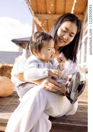 Korean mom and her cute baby in the backyard of the house. Korean mom and her cute baby in the backyard of the house. 122950041
