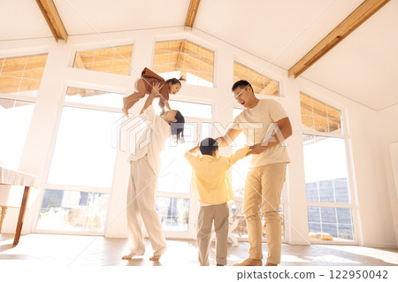 Korean young parents dancing with cute little kids in dining room 122950042