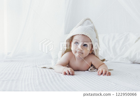 Little cute child wearing hooded towel after bath or shower. Little cute child wearing hooded towel after bath or shower. 122950066