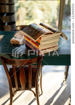Stack of Books with an Open Magazine in Sunlight 122950555