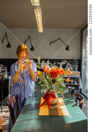 Woman Using Smartphone in a Stylish Modern Kitchen 122950596