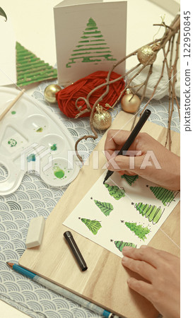 Overhead view of a hand painting stylized Christmas trees watercolors illustration to make handmade holiday season greetings card Overhead view of a hand painting stylized Christmas trees watercolors illustration to make handmade holiday season greetings card 122950845