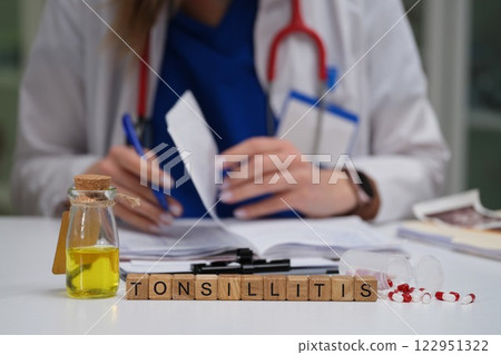 A healthcare professional diligently examining and evaluating a tonsillitis case for treatment 122951322