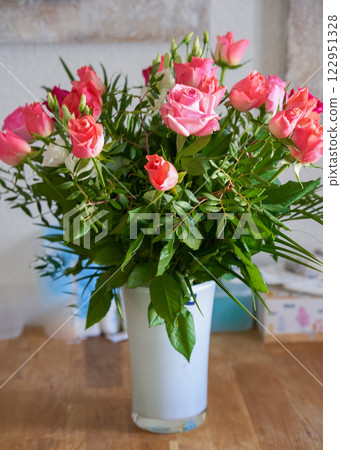 Bouquet of juicy pink roses in a white vase on a wooden table. High quality photo Bouquet of juicy pink roses in a white vase on a wooden table. High quality photo 122951328