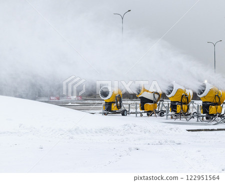 Shot of the industrial machinery so called snow gun or snow cannon that produces artificial snow in action. Shot of the industrial machinery so called snow gun or snow cannon that produces artificial snow in action. 122951564