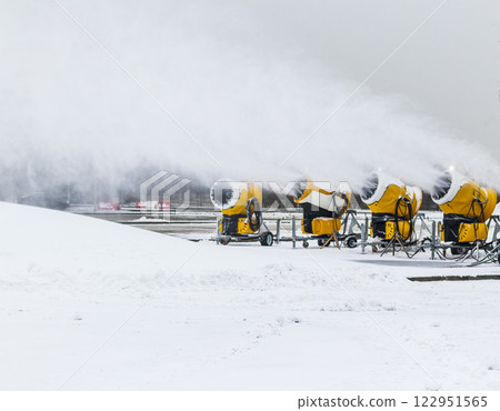 Shot of the industrial machinery so called snow gun or snow cannon that produces artificial snow in action. 122951565