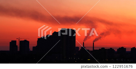 Kyiv, Ukraine June 9, 2024: Pipes smoke, polluting the air in the city, worsening the ecology against the backdrop of a red sky 122951676