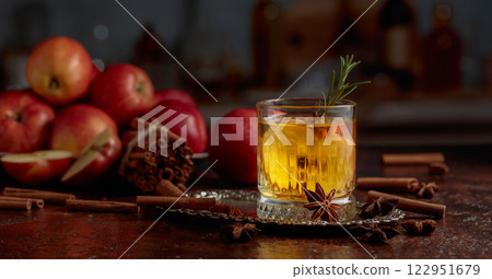 Apple cider with apple slices and a rosemary sprig. 122951679