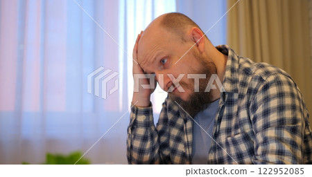 Bald man rubs forehead while stress builds in hectic workspace letting stress overshadow tasks if stress remains unchecked, warning viewers of potential burnout hazards. Remote work of man at computer Bald man rubs forehead while stress builds in hectic workspace letting stress overshadow tasks if stress remains unchecked, warning viewers of potential burnout hazards. Remote work of man at computer 122952085