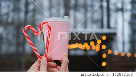 Frosty backdrop frames pink beverage with candy cane heart, revealing romance that lingers in delicate lights where romance flourishes through holiday chill unlocking romance hidden in simple gestures Frosty backdrop frames pink beverage with candy cane heart, revealing romance that lingers in delicate lights where romance flourishes through holiday chill unlocking romance hidden in simple gestures 122952108