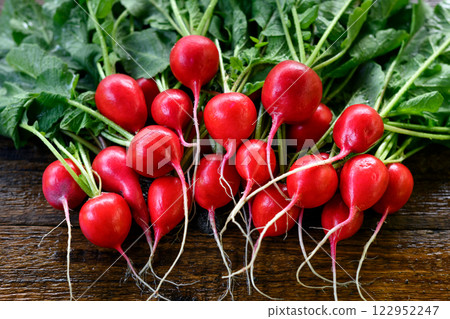 Bunch of fresh organic radish on wooden table Bunch of fresh organic radish on wooden table 122952247