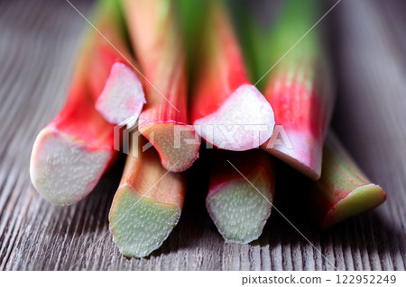 Close up of ripe rhubarb stalks on a wooden table Close up of ripe rhubarb stalks on a wooden table 122952249