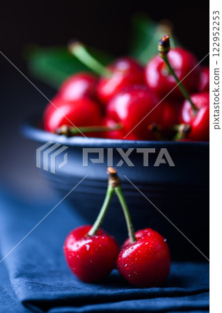 Close-up of ripe fresh red cherries on a blue tablecloth Close-up of ripe fresh red cherries on a blue tablecloth 122952253