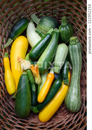 Fresh different kind zucchini and squash in wicker basket 122952258