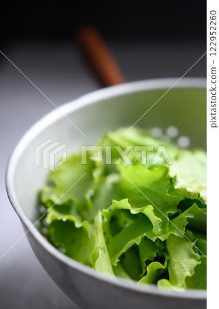 Fresh green lettuce leaves rinsed in a metal colande Fresh green lettuce leaves rinsed in a metal colande 122952260