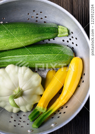 Old colander with fresh different kind zucchini and squash close up 122952284