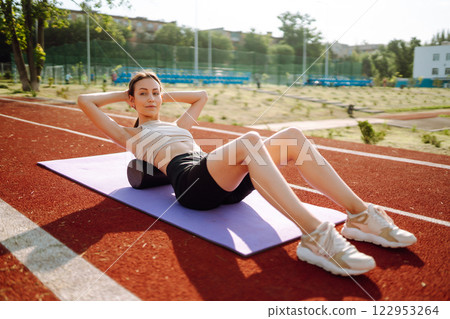 Young woman in sports outfit doing exercises outdoors in morning. Sport, Active life sports training 122953264