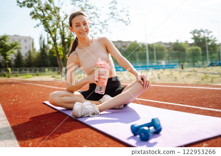 Young woman in sports outfit doing exercises outdoors in morning. Sport, Active life sports training 122953266