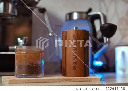 Poland, Wroclaw, 8 January 2025. Hand Coffee Grinder Comandante c40 Nitro Liquid Amber on the kitchen wooden cutting board. Close up, detailed.  122953438