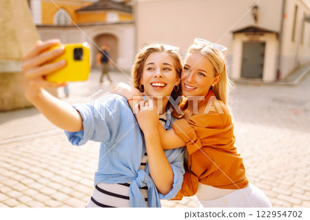 Young friends having fun and take selfie on the phone together. Entertainment, youth concept. 122954702