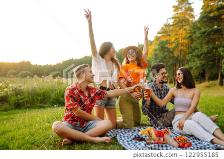 Stylish friends enjoy sunny day on beautiful green meadow. Vacation, friendship or holliday concept. Stylish friends enjoy sunny day on beautiful green meadow. Vacation, friendship or holliday concept. 122955185