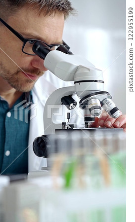 Man scientist using microscope in laboratory. Microbiology science concept 122955199
